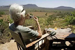 Photographing: Tourist - photographing scenery from veranda at
