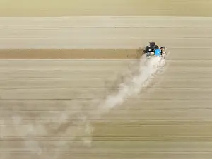 Raising: Tractor at field work. Aerial view. Drone shot
