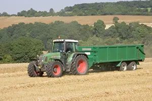 Tractors: Tractor hauling wheat from combine harvester