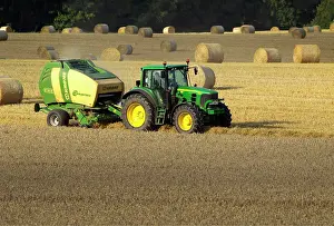 Tractors: Tractor making bales of hay in freshly cut wheat