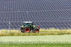 Powered: Tractor in front of solar field, solar park in the