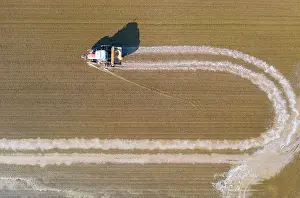 Delta: Tractor sowing rice seeds in a flooded rice field