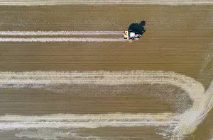 Delta: Tractor sowing rice seeds in a flooded rice field