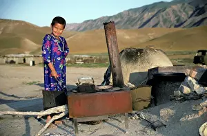 Bread: Turkmen girl - in traditional dress - boils water