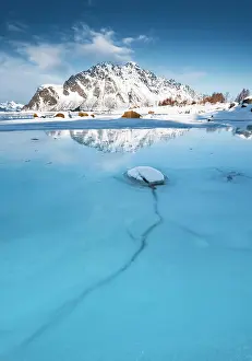 Floes: Turquoise lagoon with ice floes, behind it snow-covered