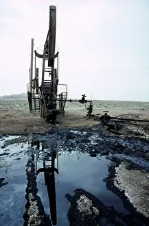 Pump: A typical oil-pump on an oil-well - with a puddle