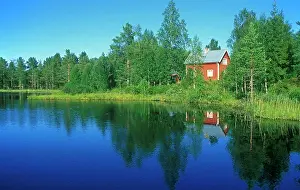 300517: Typical red wooden house beside an idyllic lake
