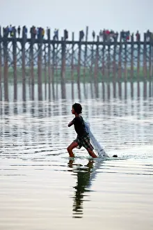 Fishermen: The U Bein Bridge with a fisherman walking across the Ta