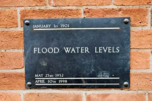 Floods: UK - Brass plate displaying high flood levels on
