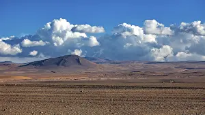 Clear: Vast desert landscape with mountains under a clear blue sky and mighty clouds