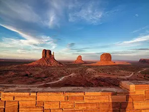 Platform: View of gravel road and mesas at sunset from the