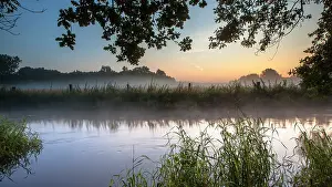 Twente: View of River Dinkel in Twente on an early summer morning with haze over the water surface