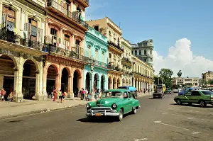 Avenues: Vintage car in front of buildings with colourful