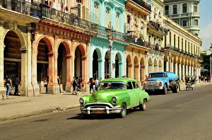 Avenues: Vintage car in front of buildings with colourful