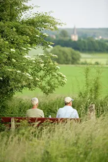 Churchtower: Walkers resting on a bench looking over the river valley of the Geul