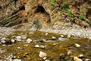 Strewn: Water flows through a rock strewn valley in the