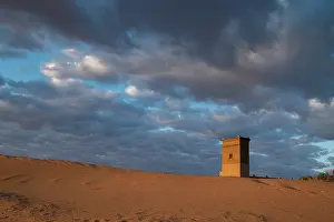 Sahara: Water tower glows orange in sunrise light