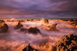 Crash: Waves crash over rocky coastline at sunrise