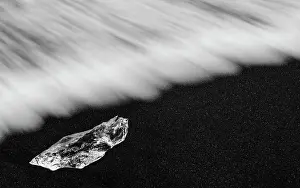 Cubes: Waves rolling over the ice cubes on the black lava beach