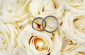 Rings: Wedding rings on a bridal bouquet, white roses