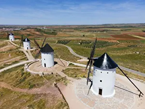 Wind: Four white windmills with black roofs on a wide