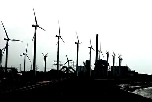 Fired: Wind Turbines and coal fired power station on the