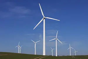 Wind: Wind turbines at windfarm in field against blue sky