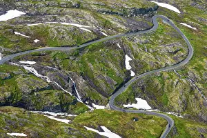 Winding: Winding road in a green landscape with patches o