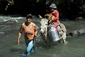 Attach: Woman holding an Ass crossing Irubi River Ecuador