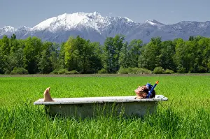 Canton: Woman lying in a bathtub on a green field with g