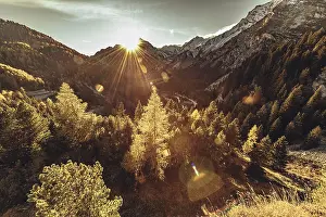 Roads: Woman sitting thoughtfully at a feslen at autumn atmosphere during sunset in the Swiss Alps in the Engadine