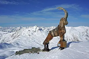 Skiing: Wooden ibex figure, work of art, snow-capped mountains
