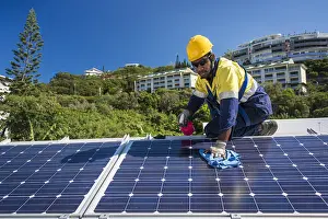 Worker: Worker cleaning solar panels, New Caledonia