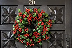 Ilex: Wreath of Holly (Ilex) with red berries on the door