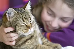 Unsharp: Ten year old girl hugging her cat