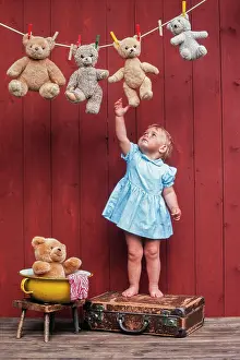 Child: Three year-old girl reaching for teddy bears on