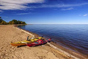 Boats: Yellow and red kayaks pulled up on the sandy beach on the shouth shore of Great Slave Lake near Hay River