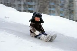 Sledging: Young boy does downhill-ice-sliding just on his