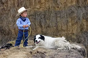 Ranches: Young boy playing at being a cowboy with Border Collie dog