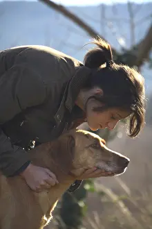 Wheedle: A young girl caressing a dog