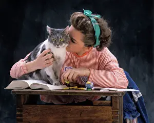 Stroking: Young Girl with Cat on school desk