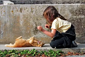 Teasing: Young Girl - playing / teasing ginger tabby cat