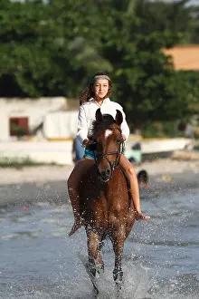 Halter: Young girl riding bareback in the sea - Senegal