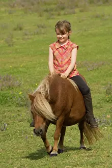 Minature: Young girl riding Shetland Pony