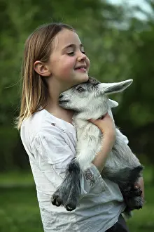 Held: Young goat in the arms of a little girl - Tuscany