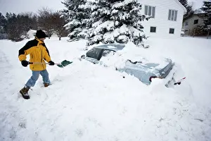 2007: Young man digging out car after snow storm, after