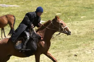 Peoples: Young nomadic horseman galloping in a meadow Kyrgyzstan