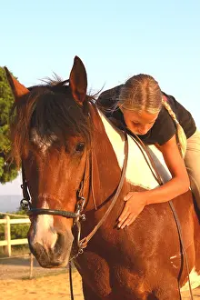 Exercise: Young rider caressing her Horse after doing an exercise