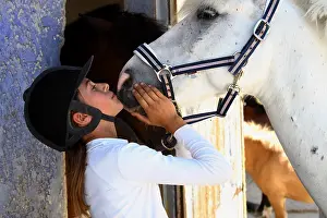 Kisses: Young rider kissing her Horse