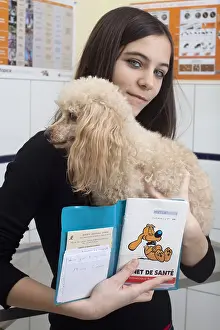 Book: Young woman carrying her poodle and the book of the animal